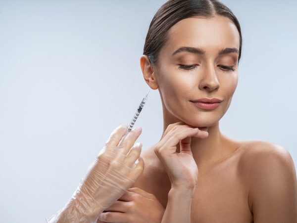 Prick of beauty. Beautiful girl standing isolated on white and preparing for beauty procedure