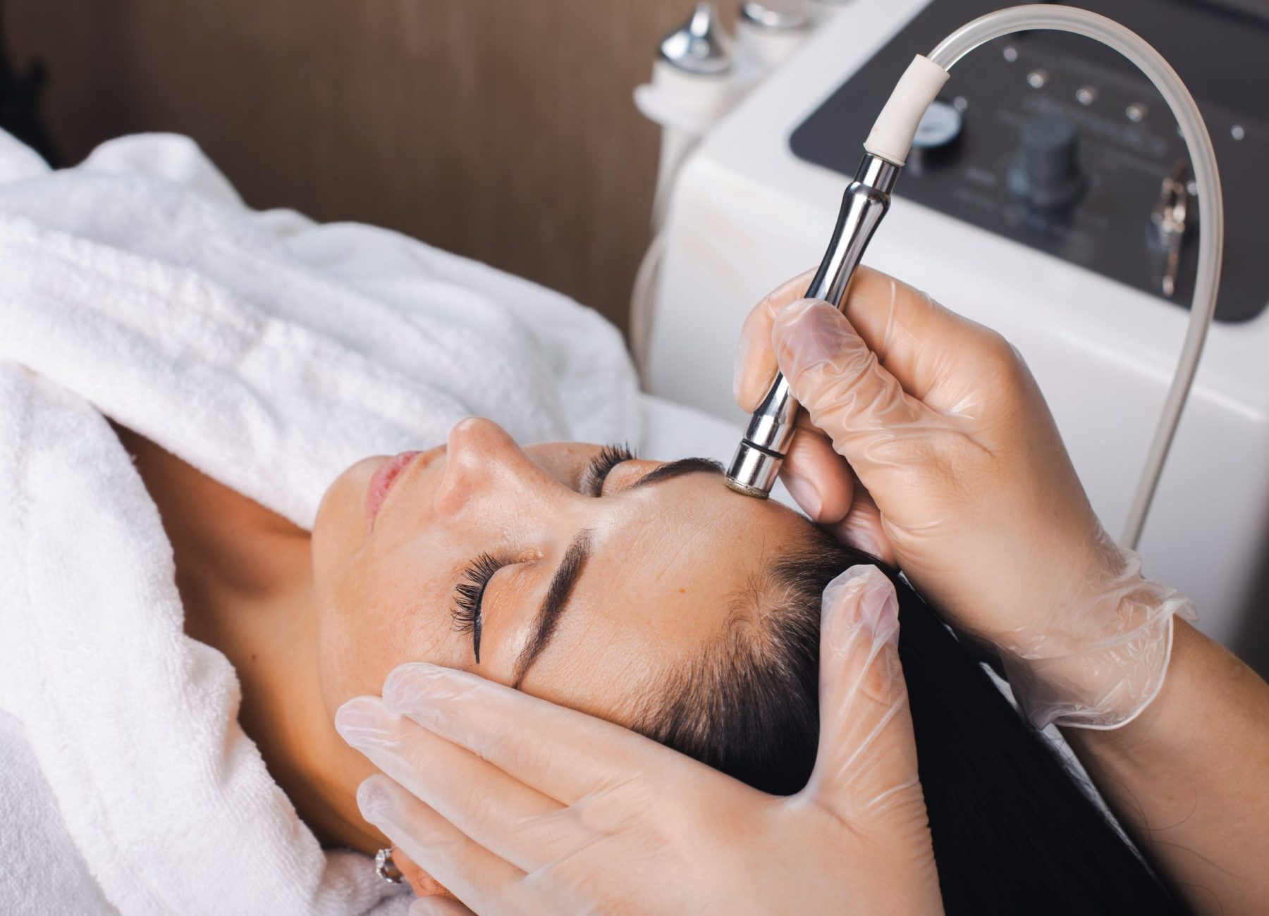 Cosmetologist's hand is making cavitation rejuvenation skin treatment. Facial treatment. Facial skincare. Beauty skin care. Rejuvenation treatment.