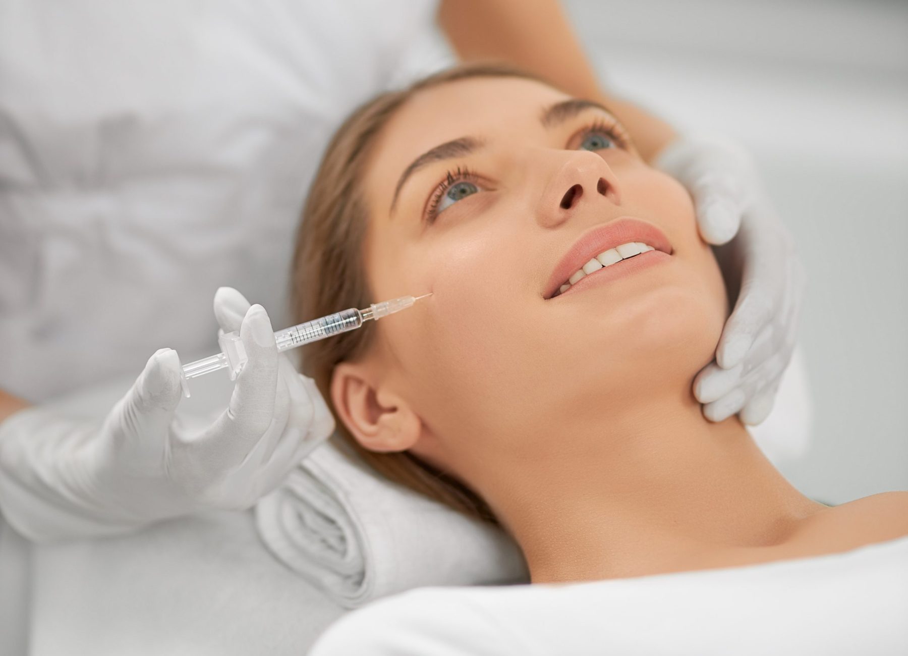 Smiling woman doing procedure for tighten skin.