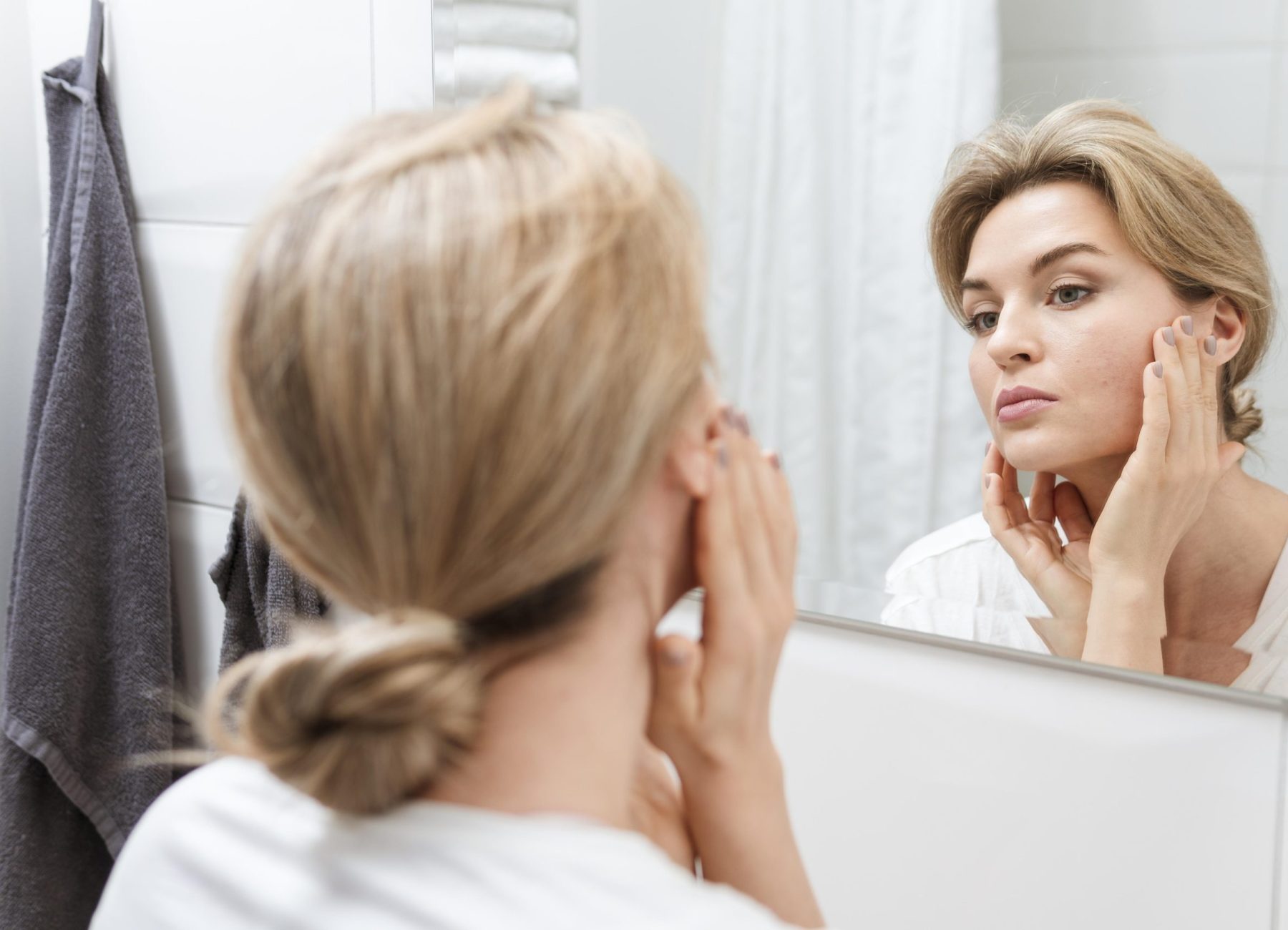 woman-towel-checking-herself-mirror