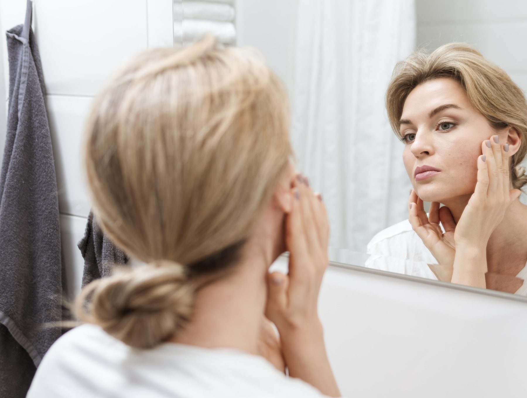 woman-towel-checking-herself-mirror